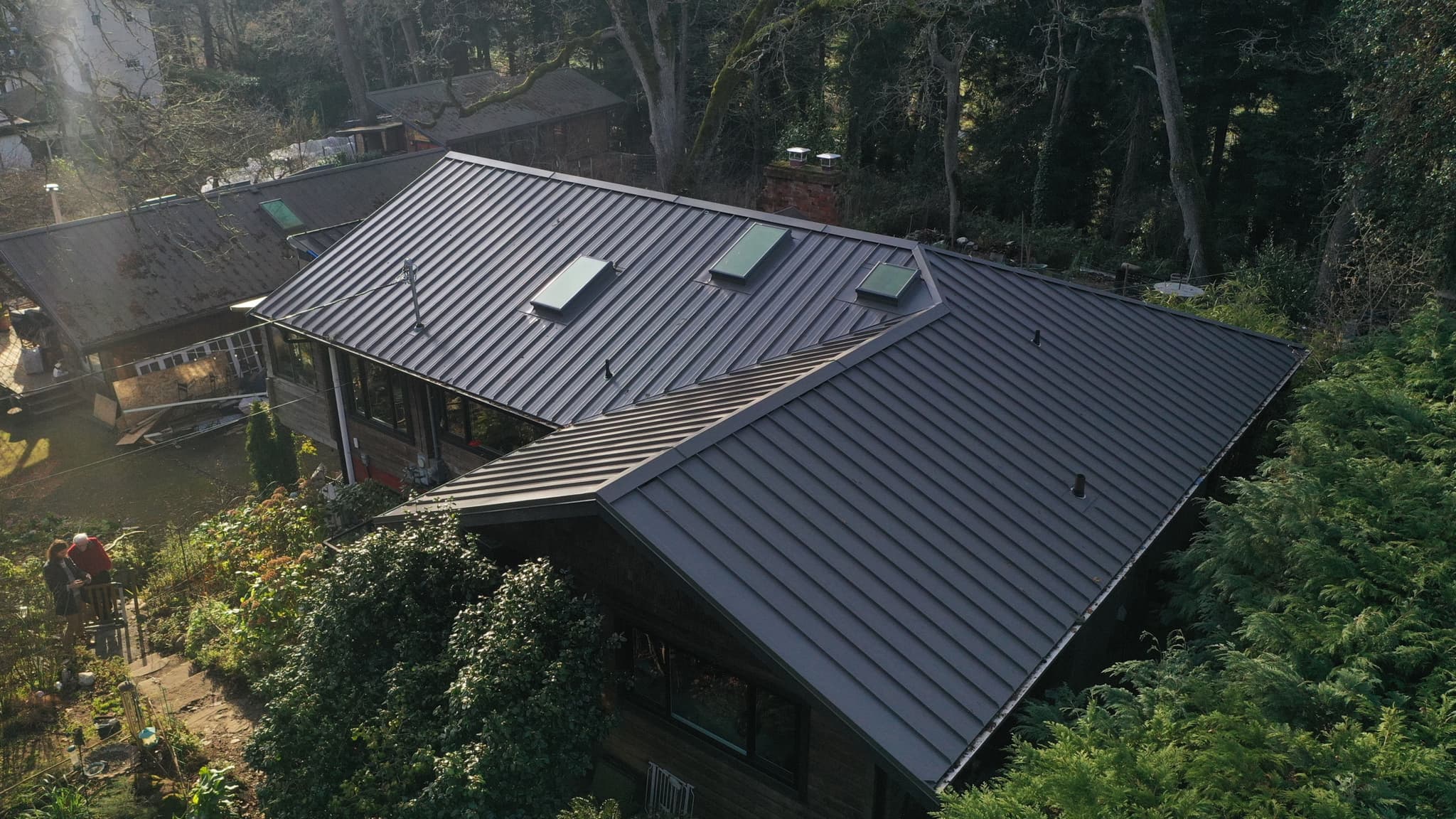 Glendenning home with an Aspen metal roof surrounded by trees